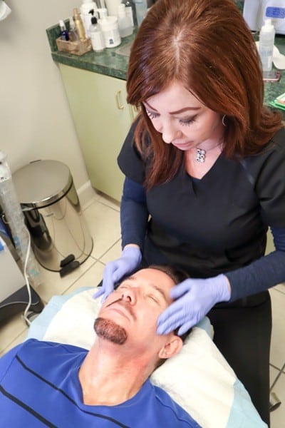 aesthetician performing non-surgical HydraFacial treatment on male patient
